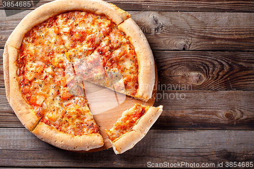 Image of Delicious italian pizza with one eating piece