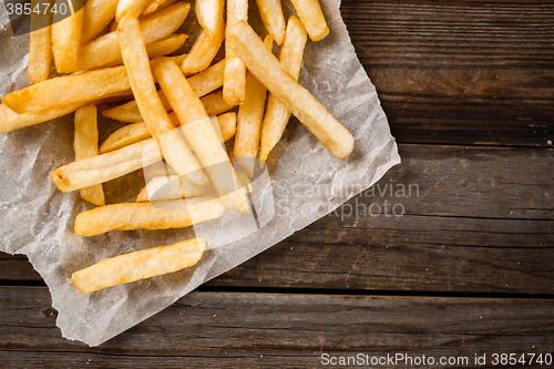 Image of French fries on wooden table.