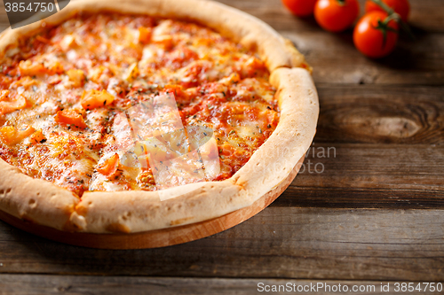 Image of Tasty pizza on old wooden table.