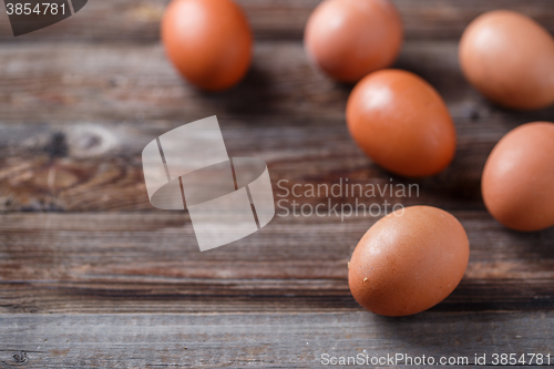 Image of Brown eggs on a rustic wooden table