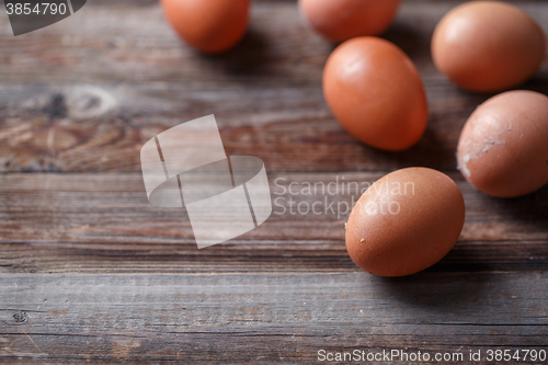 Image of Brown eggs on a rustic wooden table