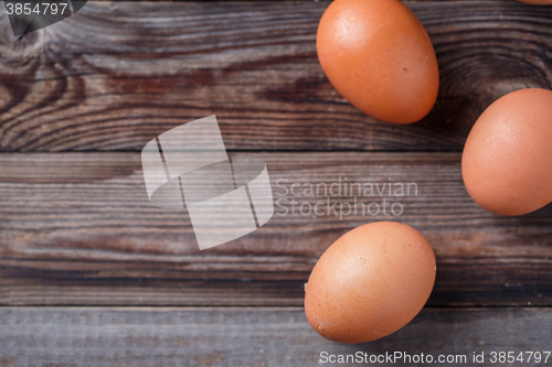 Image of Brown eggs on a rustic wooden table