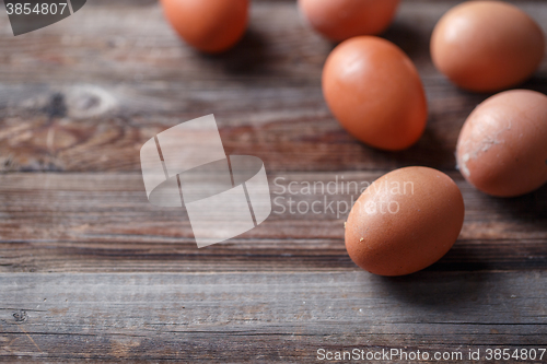 Image of Brown eggs on a rustic wooden table