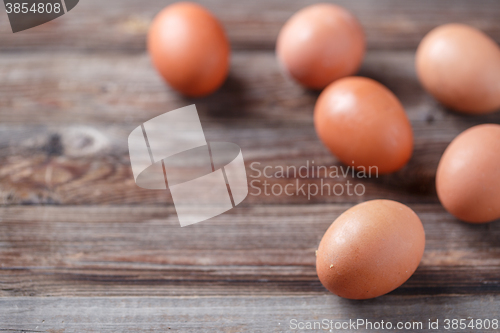 Image of Brown eggs on a rustic wooden table