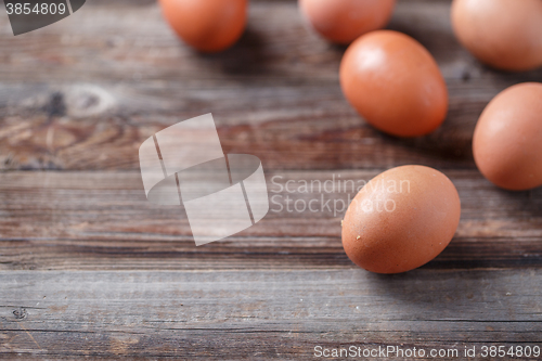 Image of Brown eggs on a rustic wooden table