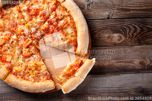 Image of Delicious italian pizza with one eating piece
