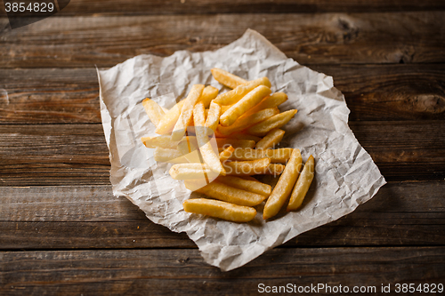 Image of French fries on wooden table.