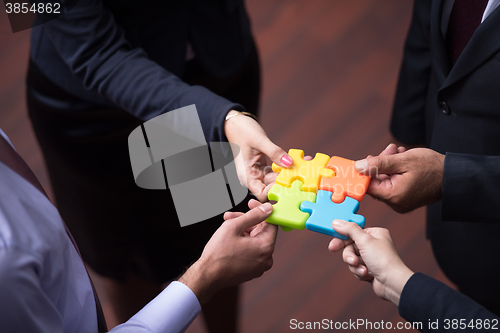 Image of top view of business people group assembling jigsaw puzzle