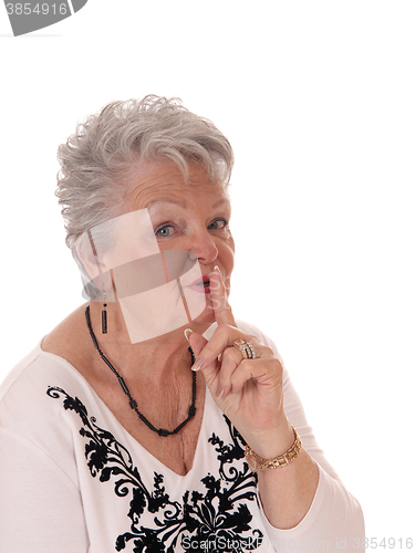 Image of Senior woman with finger over mouth.