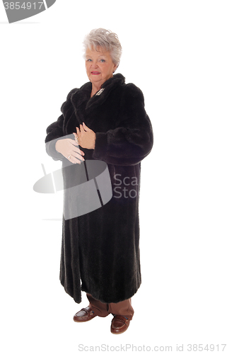 Image of Senior woman standing in fur coat.