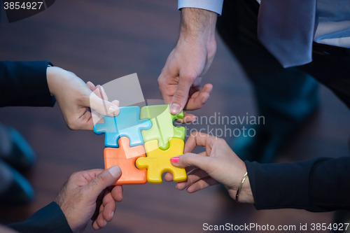 Image of top view of business people group assembling jigsaw puzzle