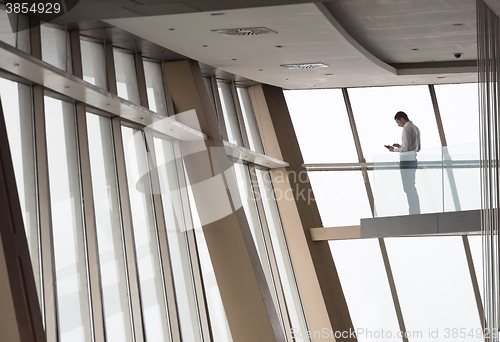 Image of young successful business man in penthouse apartment working on 