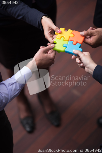 Image of top view of business people group assembling jigsaw puzzle