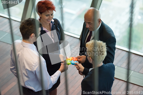 Image of top view of business people group assembling jigsaw puzzle