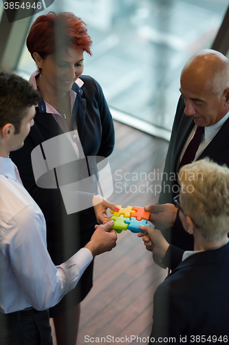 Image of top view of business people group assembling jigsaw puzzle