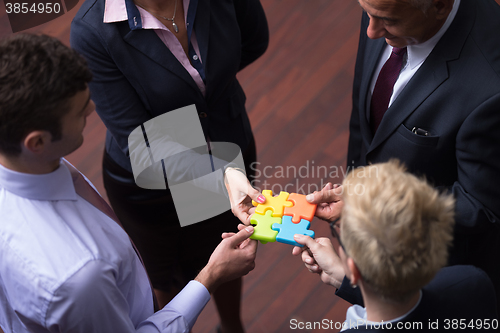 Image of top view of business people group assembling jigsaw puzzle