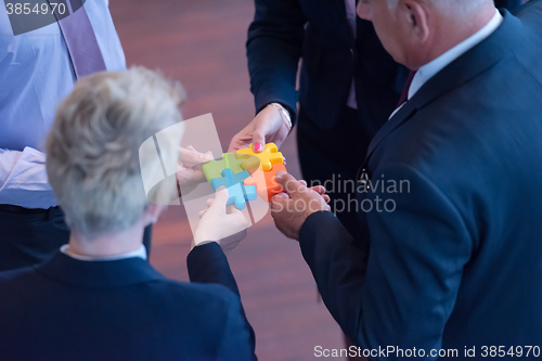 Image of top view of business people group assembling jigsaw puzzle