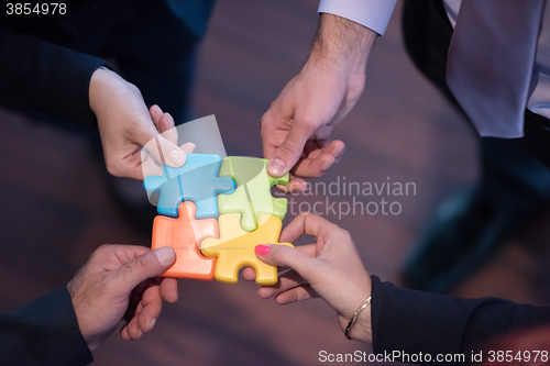 Image of top view of business people group assembling jigsaw puzzle