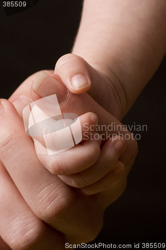 Image of Baby's hand gripping adult finger