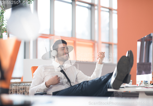 Image of relaxed young business man at office