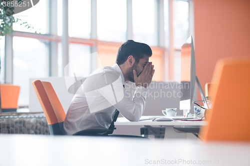 Image of frustrated young business man at work