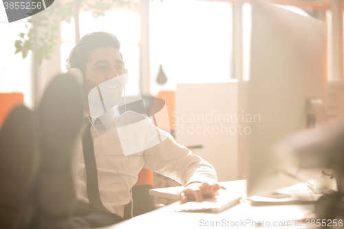 Image of relaxed young business man at office