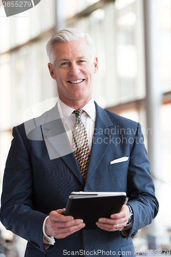 Image of senior business man working on tablet computer