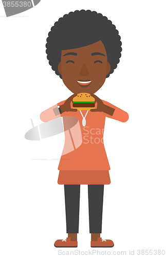 Image of Woman eating hamburger. 