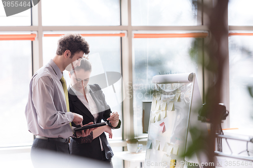 Image of young couple working on flip board at office