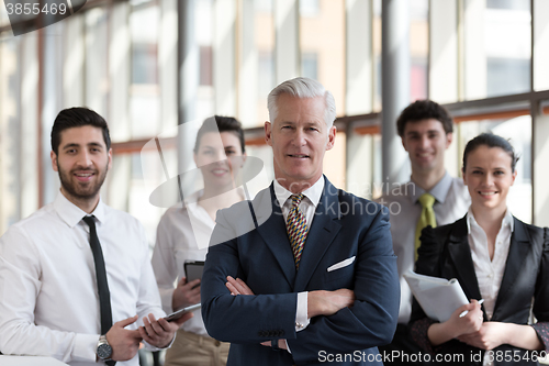 Image of portrait of senior businessman as leader  with group of people i