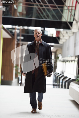 Image of handsome senior business man walking