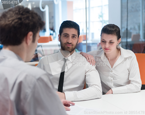 Image of young couple signing contract documents on partners back