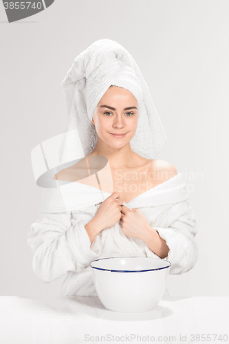 Image of Woman cleaning face in bathroom