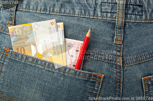 Image of Swiss money and lottery bet slip in pocket