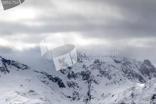 Image of Snowy mountains in haze and storm clouds