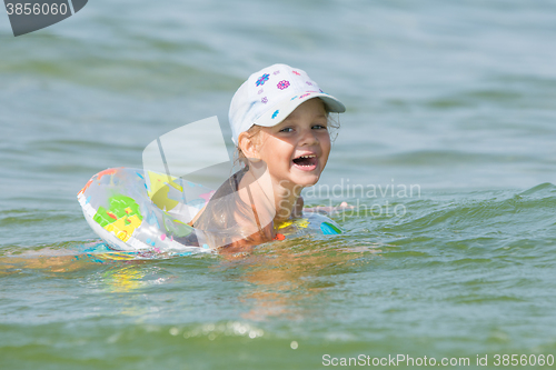 Image of Joyful little girl swimming in a pond at the children\'s circle