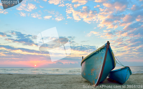Image of sunrise over an  wooden fishing boats