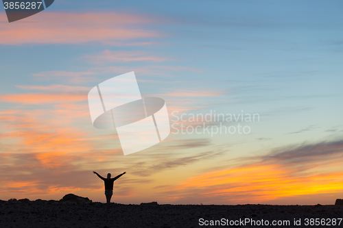 Image of Woman enjoying freedom at sunset.