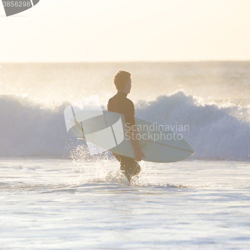 Image of Surfers on beach with surfboard.