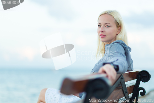 Image of Lady sitting on a bench outdoors