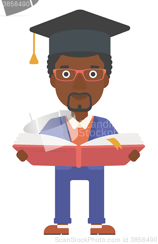 Image of Man in graduation cap holding book.