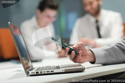 Image of close up of  businessman hands  using smart phone on meeting