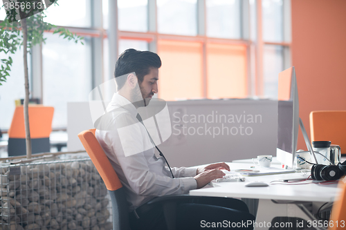 Image of young business man  working on desktop computer