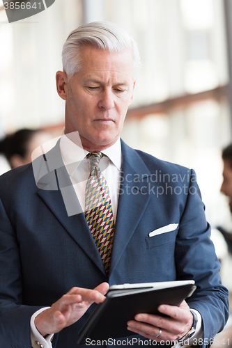 Image of senior business man working on tablet computer