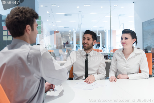 Image of young couple signing contract documents on partners back