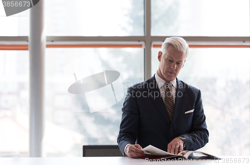 Image of senior business man reading magazine