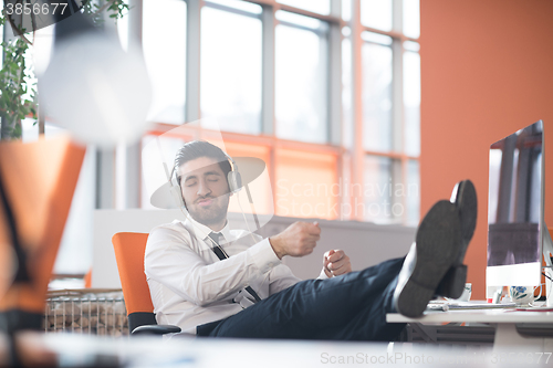 Image of relaxed young business man at office