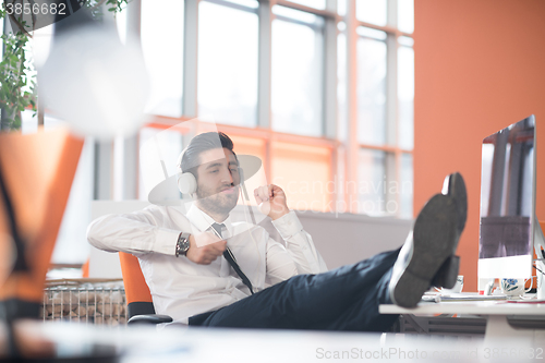 Image of relaxed young business man at office