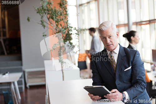 Image of senior business man working on tablet computer