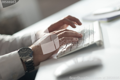 Image of hands typing on desktop computer